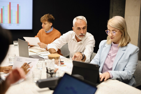 Three team members at conference table looking at organizational culture survey